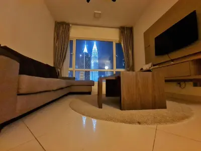 a living room with a couch and a large window at Crest Residence Klcc by Sarah's Lodge in Kuala Lumpur