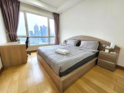 a bedroom with a bed with a desk and a window at Crest Residence Klcc by Sarah's Lodge in Kuala Lumpur