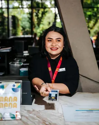 a woman sitting at a table holding a cell phone at EXPRESSIONZ KLCC BY MANA-MANA in Kuala Lumpur