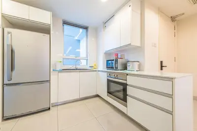 a kitchen with white cabinets and a refrigerator at MITEC Publika 2Br Hot tub Sri Hartamas Mont Kiara in Kuala Lumpur