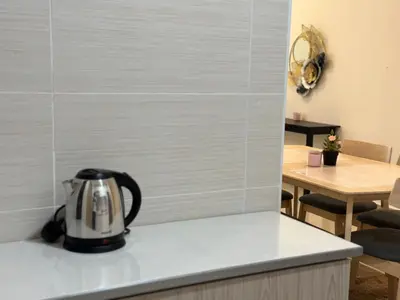 a tea kettle on a kitchen counter with a table at KLCC Kampung Baru Cottage - Homestay in Kuala Lumpur