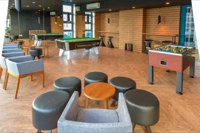 a room with a ping pong table and some chairs at S36- Robertson at Bukit Bintang 3 Bedroom with Netflix in Kuala Lumpur