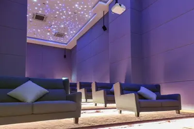 a waiting room with a couch and a purple wall at S27- Bukit Bintang Robertson 3BR Suite with Netflix in Kuala Lumpur