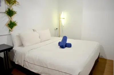 a blue stuffed animal sitting on top of a bed at RED ROOM Kuala Lumpur in Kuala Lumpur
