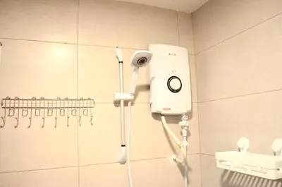 a shower in a bathroom with a blow dryer on the wall at RED ROOM Kuala Lumpur in Kuala Lumpur