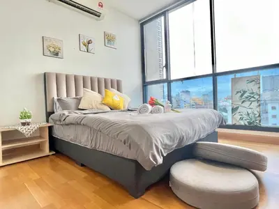 a bedroom with a bed with a chair and a window at KL Gateway 2B2B Cozy apartment in Kuala Lumpur