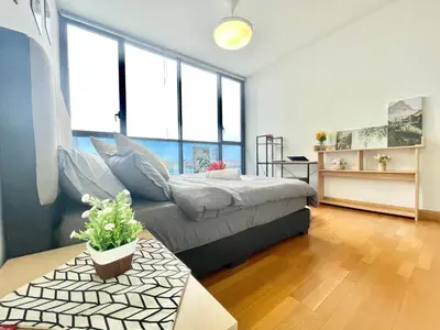 a bedroom with a bed and a table and some windows at KL Gateway 2B2B Cozy apartment in Kuala Lumpur