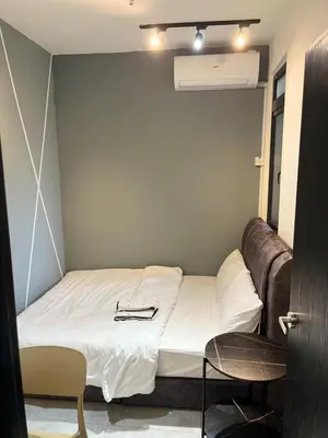 a small bedroom with a bed with a leather couch at Neu suites 007- 2 bedrooms klcc in Kuala Lumpur