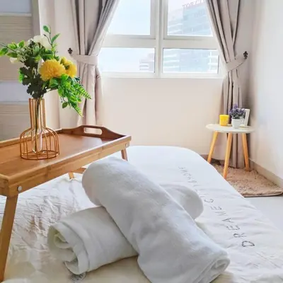 a pile of towels on a bed next to a table at Titiwangsa 6PX near monorail PWTC Infinity pool in Kuala Lumpur