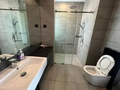 a bathroom with a shower and a toilet and a sink at Opus Residences KL Merdeka 118 View in Kuala Lumpur