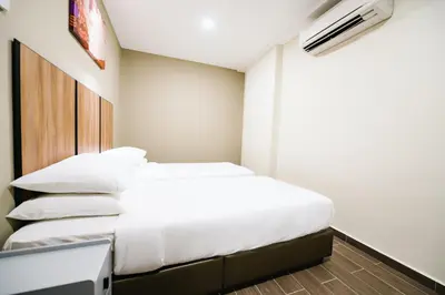 a small bedroom with two beds and a television at Chill Suites Kuala Lumpur in Kuala Lumpur