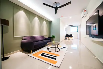 a living room with a purple couch and a tv at Chill Suites Kuala Lumpur in Kuala Lumpur