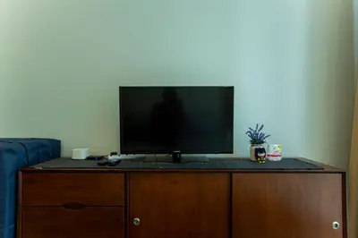 a flat screen tv sitting on top of a wooden cabinet at Kuala Lumpur Kids Friendly Playground Bunk Bed in Kuala Lumpur