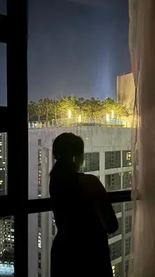 a woman standing in front of a window looking at a city at Skyline view in Bukit Bintang The Robertson 42f in Kuala Lumpur
