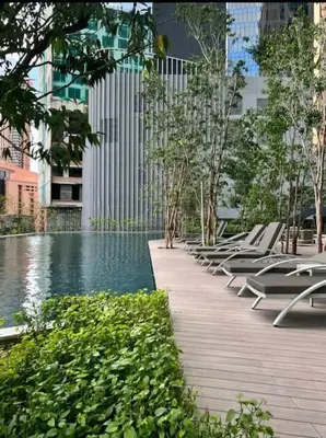 a row of lounge chairs next to a swimming pool at Lucentia Residence By Home Horizon in Kuala Lumpur