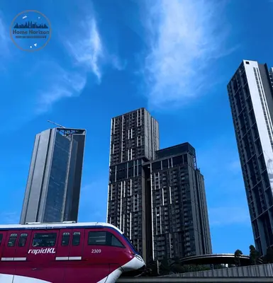 a red train in front of some tall buildings at Lucentia Residence By Home Horizon in Kuala Lumpur