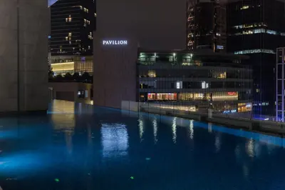 a pool in the middle of a city at night at Bukit Bintang Signatures Pavilion Kuala Lumpur in Kuala Lumpur
