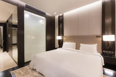 a bedroom with a large white bed and a mirror at Bukit Bintang Signatures Pavilion Kuala Lumpur in Kuala Lumpur