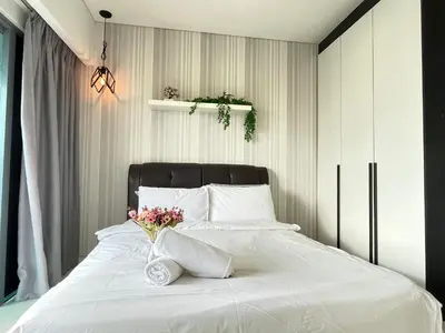 a bedroom with a white bed with flowers on it at Mercu Summer Suite KLCC by Kuminshu in Kuala Lumpur