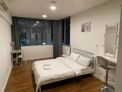 a bedroom with a bed and a desk and a window at Mercu Summer Suite KLCC by Kuminshu in Kuala Lumpur