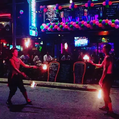 two men are dancing in the street at night at Roomy Suites @One Bukit Ceylon in Kuala Lumpur