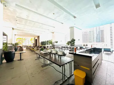 a large room with tables and chairs in a building at Roomy Suites @One Bukit Ceylon in Kuala Lumpur
