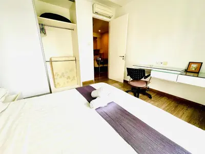 a hotel room with two beds and a desk at Roomy Suites @One Bukit Ceylon in Kuala Lumpur
