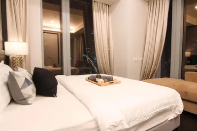 a hotel room with two beds with a tray on it at Tropicana The Residences KLCC, Premium in Kuala Lumpur
