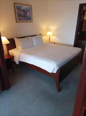 a bedroom with a large bed with two lamps on it at TM SUITE at BERJAYA TIME SQUARE KL in Kuala Lumpur