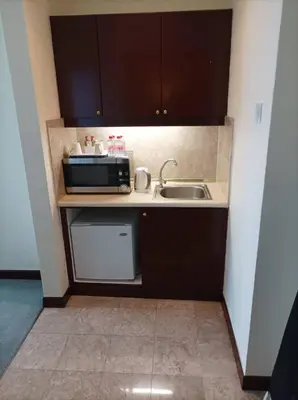 a small kitchen with a sink and a microwave at TM SUITE at BERJAYA TIME SQUARE KL in Kuala Lumpur