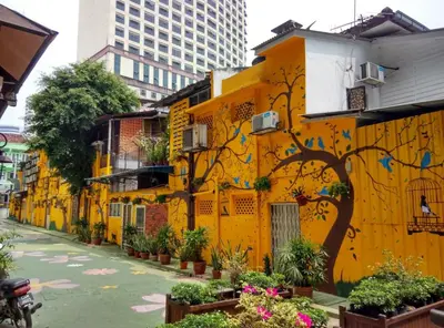 a yellow building with a tree painted on it at Red Velvet Inn Bukit Bintang in Kuala Lumpur
