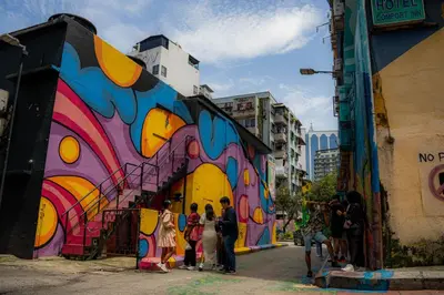 a group of people standing in front of a building with a mural at Red Velvet Inn Bukit Bintang in Kuala Lumpur