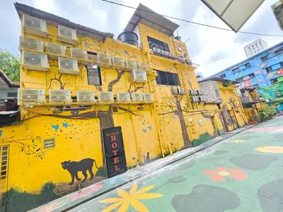 a yellow building with a painting on the side of it at Red Velvet Inn Bukit Bintang in Kuala Lumpur