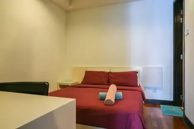 a bedroom with a red bed with a pillow on it at Casa Residency Service Apartment in Kuala Lumpur