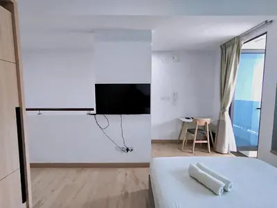 a bedroom with a bed and a tv on a wall at The Colony KLCC view by NZV in Kuala Lumpur