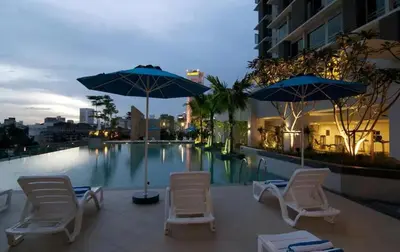 a group of chairs and umbrellas next to a swimming pool at Meta @ Swiss Garden Residence KL Bukit Bintang in Kuala Lumpur