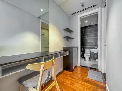 a bathroom with a vanity with a chair and a mirror at Anggun Residence Serviced Suites By BedStay in Kuala Lumpur