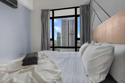 a bedroom with a white bed and a large window at Anggun Residence Serviced Suites By BedStay in Kuala Lumpur