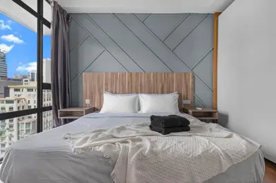 a bedroom with a large bed with a large window at Anggun Residence Serviced Suites By BedStay in Kuala Lumpur
