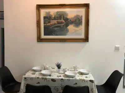 a table with a white table cloth and a picture on the wall at TR Residence 3R2B Serviced Apt 5-6pax HKL,IJN,PWTC KL in Kuala Lumpur