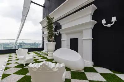 a bathroom with a white tub on a green floor at Arte Mont Kiara Hotel Suite in Kuala Lumpur