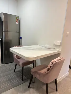 a kitchen with a table and two chairs and a refrigerator at The Ooak Suites by Bamboo Hospitality in Kuala Lumpur