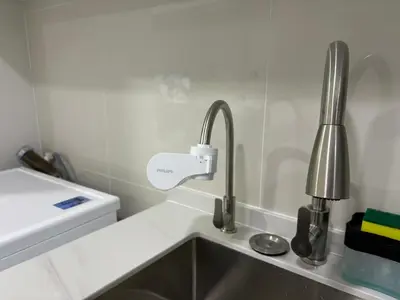 a kitchen counter with a sink and a faucet at The Ooak Suites by Bamboo Hospitality in Kuala Lumpur