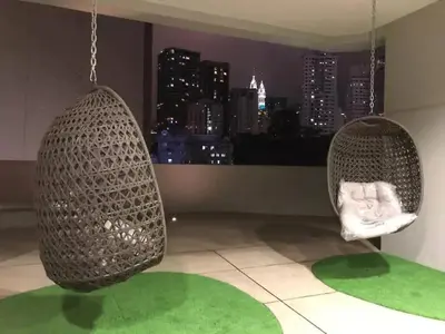 two hanging chairs in a room with a city skyline at Meta @ Robertson KL Bukit Bintang in Kuala Lumpur