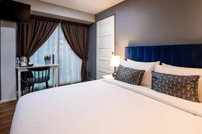 a bedroom with a large bed with a blue headboard at Raissa Boutique Hotel in Kuala Lumpur
