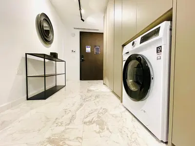 a washing machine in a laundry room with a door at EatonResidences KLCC by MAH in Kuala Lumpur