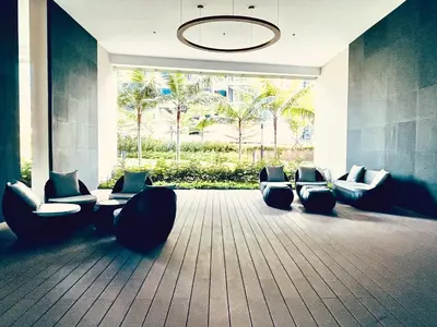 a lobby with chairs and a chandelier and palm trees at EatonResidences KLCC by MAH in Kuala Lumpur