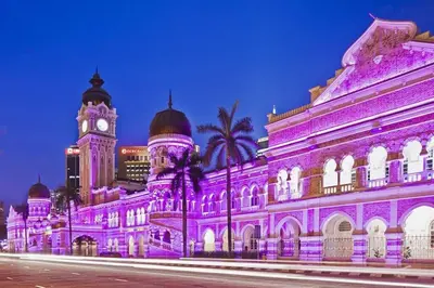 a building lit up in purple with a clock tower at Stylish & Cozy TTDI Ascencia Studio FREE Parking in Kuala Lumpur