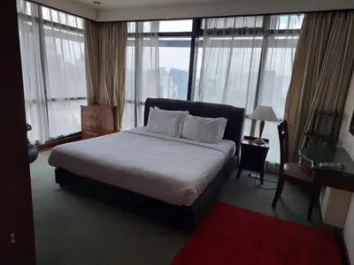 a hotel room with a bed and a desk and windows at TWO BEDROOM SUITES at TIMES SQUARE KL in Kuala Lumpur