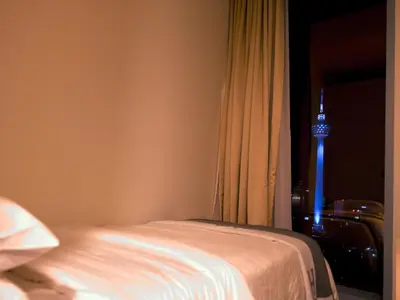a bedroom with a bed and a window with a television at Tropicana The Residences - KLCC VIEW Luxury Apartment Collections in Kuala Lumpur